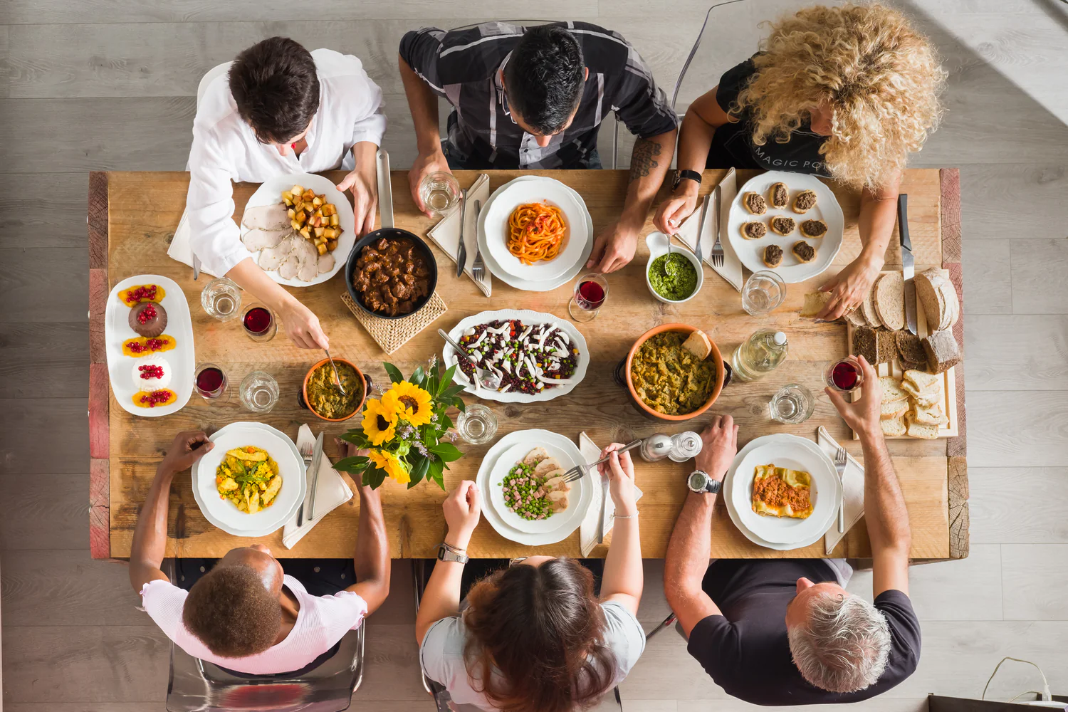 Overhead view of a shared wooden table filled with Zietta regional Italian dishes and antipasti